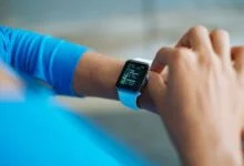 person in blue long sleeve shirt using smart watch